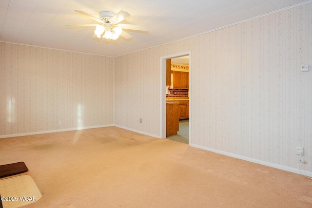 carpeted spare room featuring crown molding and ceiling fan