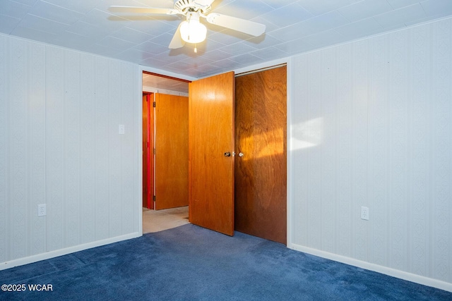 unfurnished room featuring ceiling fan and carpet