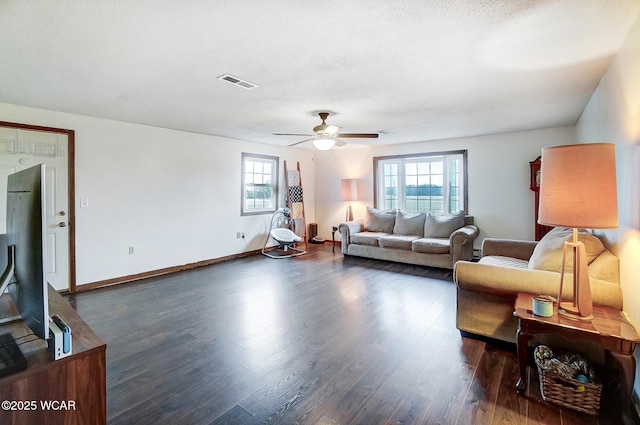 living room featuring ceiling fan, plenty of natural light, a textured ceiling, and dark hardwood / wood-style flooring