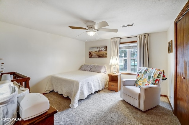 bedroom with light carpet, a textured ceiling, and ceiling fan