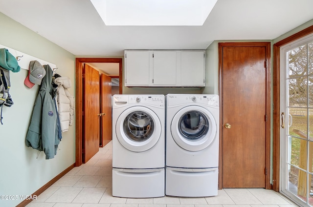 laundry room with cabinets, washer and dryer, and light tile patterned floors