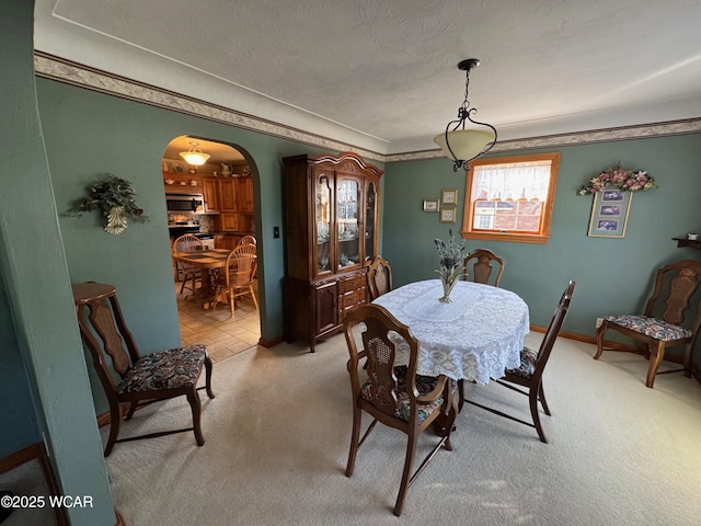 242 S Main St, Ottawa, OH 45875 - dining space with arched walkways, light carpet, and a textured ceiling
