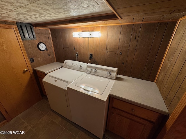 242 S Main St, Ottawa, OH 45875 - laundry area with wooden walls, independent washer and dryer, cabinet space, and dark tile patterned flooring