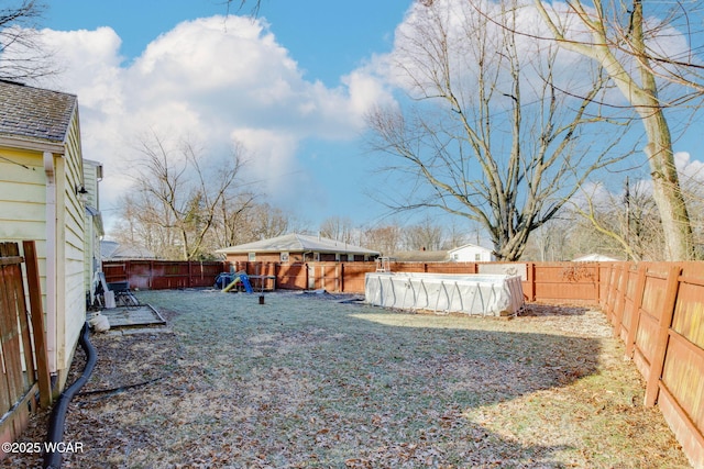 view of yard with a playground and a covered pool