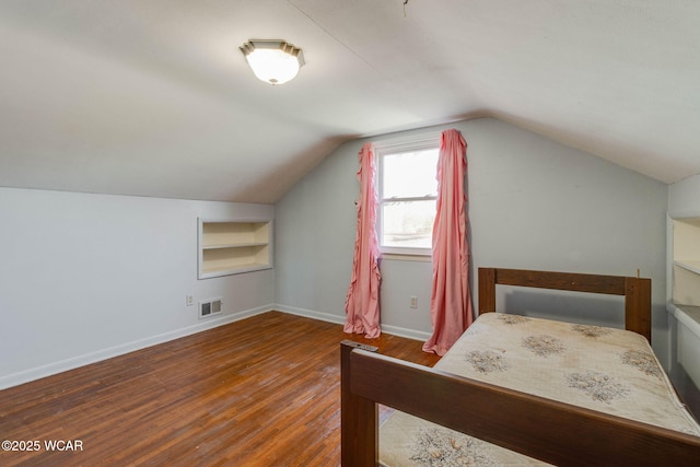 bedroom with dark hardwood / wood-style flooring and vaulted ceiling