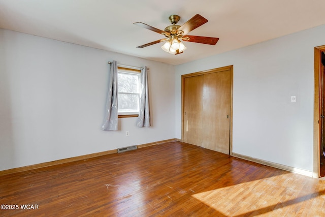 unfurnished bedroom with ceiling fan, wood-type flooring, and a closet