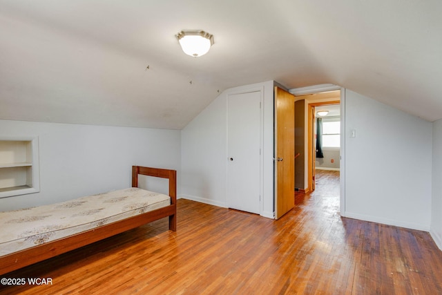 bedroom with wood-type flooring and vaulted ceiling