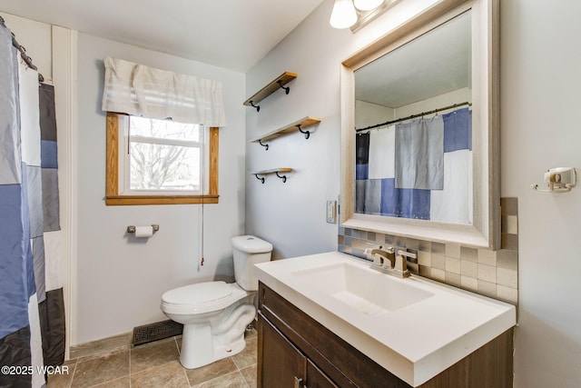 bathroom featuring tasteful backsplash, vanity, and toilet