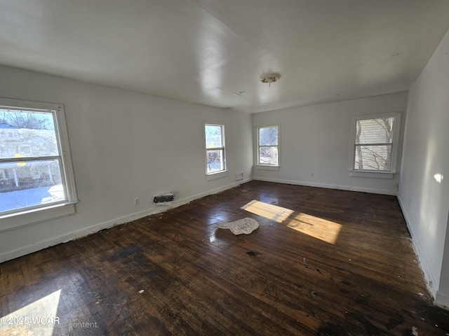 unfurnished room featuring dark wood-style flooring and baseboards