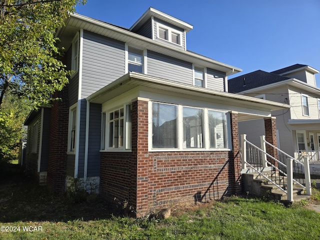 american foursquare style home with brick siding