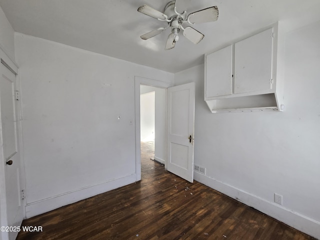 unfurnished room featuring baseboards, visible vents, ceiling fan, and dark wood-type flooring