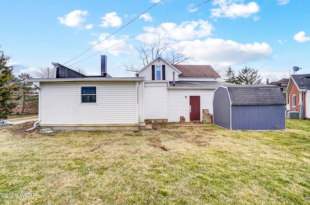 back of house with an outbuilding, central air condition unit, a storage shed, and a yard