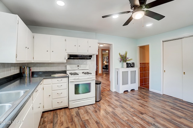 kitchen with a sink, ventilation hood, light wood-style floors, white cabinets, and white range with gas stovetop