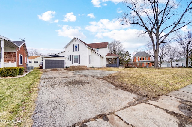 view of front of house with a garage, driveway, a front lawn, and an outdoor structure