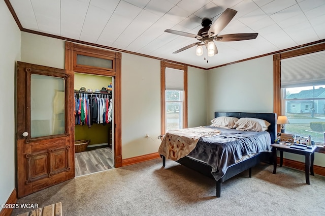 bedroom featuring baseboards, multiple windows, carpet, and ornamental molding