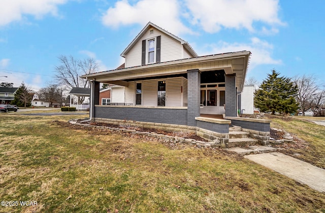 view of front of house with brick siding, a porch, and a front yard