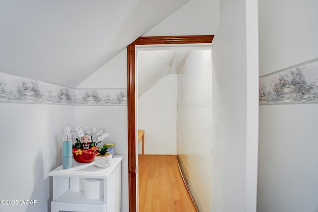 hallway featuring light wood-type flooring and lofted ceiling