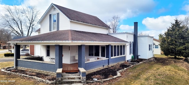 view of front of house featuring brick siding, covered porch, and a shingled roof