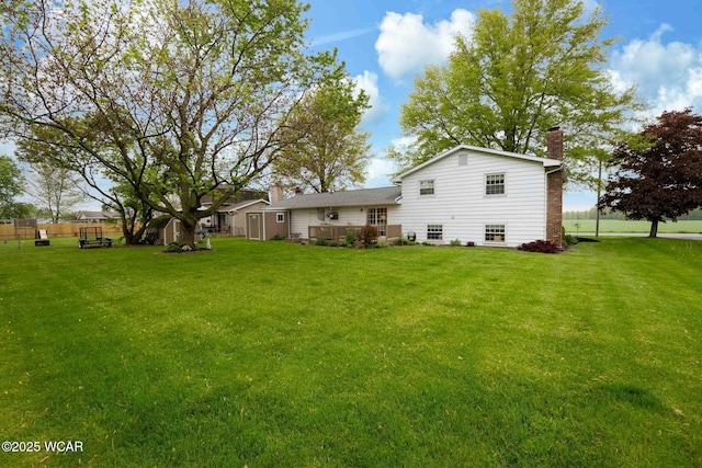 2440 E Bluelick Rd, Lima, OH 45801 - rear view of property featuring a chimney, a yard, and a deck