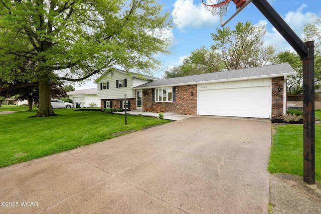 2440 E Bluelick Rd, Lima, OH 45801 - split level home featuring brick siding, an attached garage, a front yard, and concrete driveway