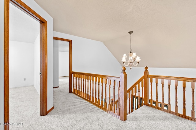 800 Heritage Dr, Lima, OH 45804 - hallway with carpet floors, a chandelier, vaulted ceiling, and an upstairs landing
