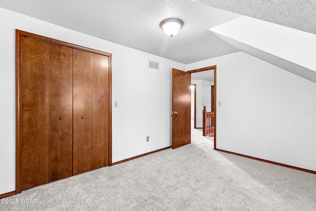 800 Heritage Dr, Lima, OH 45804 - unfurnished bedroom with carpet, a closet, a textured ceiling, and vaulted ceiling