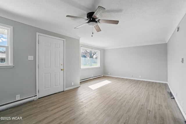 402 S Fifth St, Continental, OH 45831 - unfurnished living room featuring ceiling fan, a baseboard heating unit, a textured ceiling, and light wood finished floors