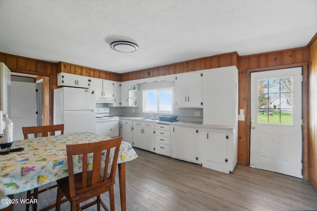 402 S Fifth St, Continental, OH 45831 - kitchen featuring light countertops, wood walls, white cabinetry, and white appliances
