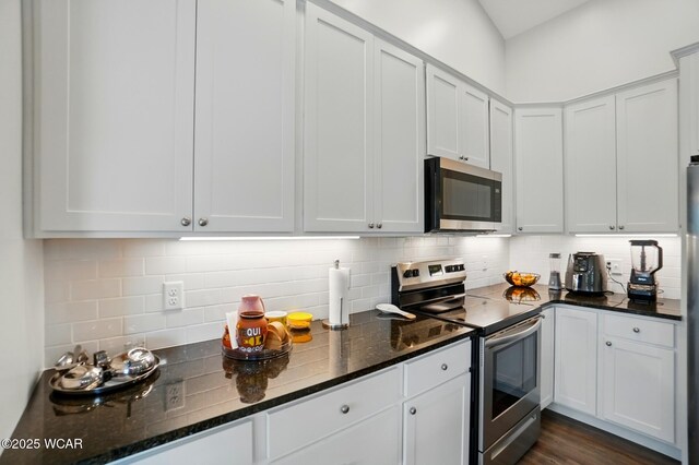 3467 Weldon Dr, Lima, OH 45806 - kitchen with appliances with stainless steel finishes, backsplash, dark stone countertops, dark wood-style flooring, and white cabinets