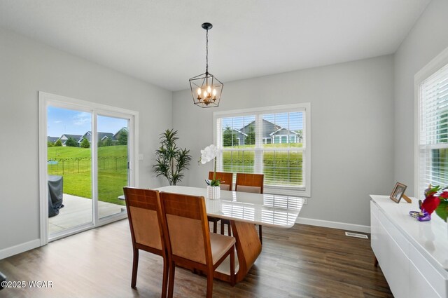 3467 Weldon Dr, Lima, OH 45806 - dining room with a chandelier, healthy amount of natural light, dark wood-type flooring, and baseboards