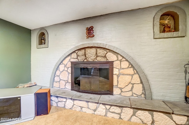 room details featuring carpet floors and a stone fireplace