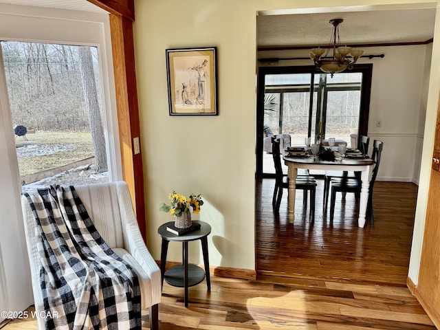 dining area featuring baseboards, an inviting chandelier, and wood finished floors