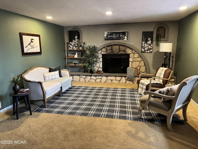 sitting room featuring recessed lighting, dark carpet, a stone fireplace, a textured ceiling, and baseboards