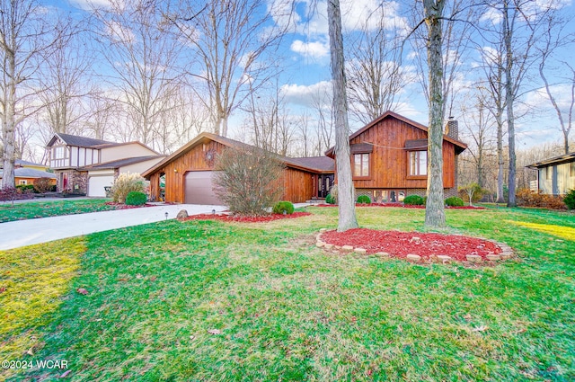 view of front of home with driveway, a garage, a chimney, and a front yard