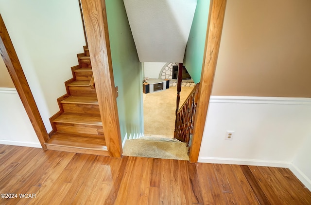 staircase featuring baseboards and wood finished floors