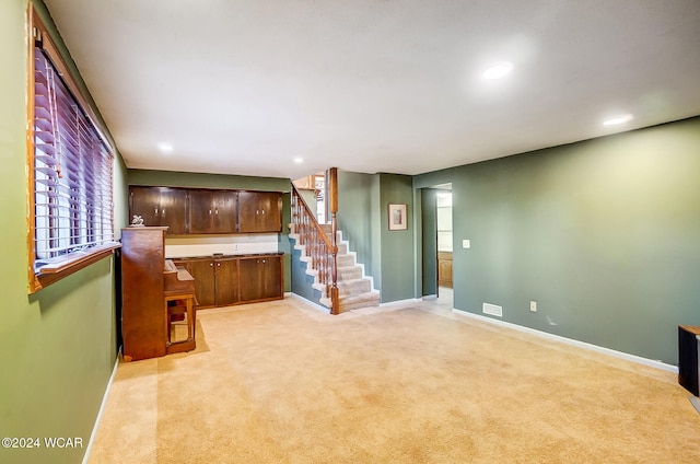 living area featuring recessed lighting, light carpet, baseboards, and stairs