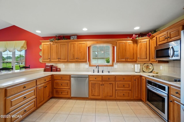 4042 Bur Oak Trl, Lima, OH 45807 - kitchen with appliances with stainless steel finishes, a sink, decorative backsplash, brown cabinets, and recessed lighting
