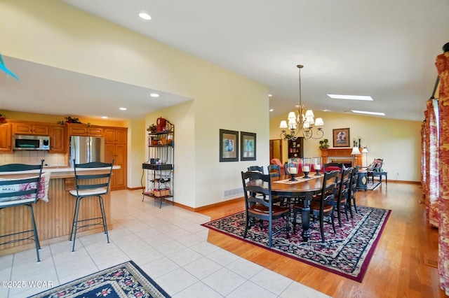 4042 Bur Oak Trl, Lima, OH 45807 - dining space with a chandelier, lofted ceiling, light tile patterned floors, baseboards, and recessed lighting