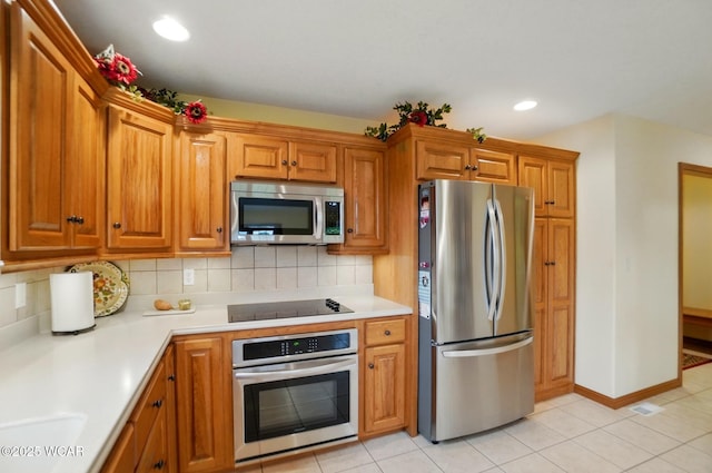 4042 Bur Oak Trl, Lima, OH 45807 - kitchen featuring stainless steel appliances, tasteful backsplash, light countertops, brown cabinets, and recessed lighting