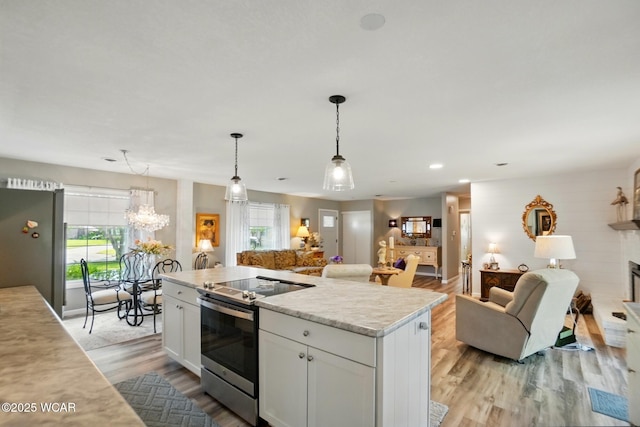 2101 Kimberly Dr, Lima, OH 45805 - kitchen featuring stainless steel electric range oven, open floor plan, light countertops, white cabinetry, and light wood-style floors