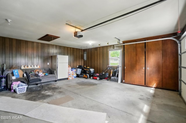 2101 Kimberly Dr, Lima, OH 45805 - garage featuring freestanding refrigerator, a garage door opener, and wood walls
