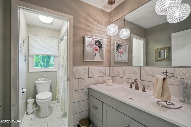 2101 Kimberly Dr, Lima, OH 45805 - full bathroom featuring toilet, vanity, a chandelier, marble look tiles, and tile walls