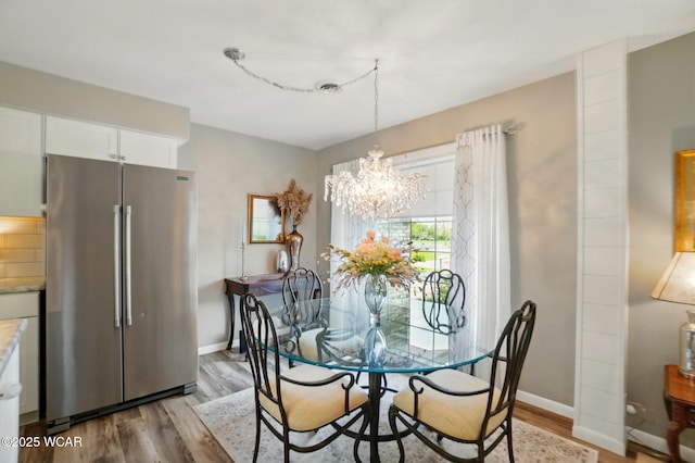 2101 Kimberly Dr, Lima, OH 45805 - dining room with wood finished floors, a chandelier, and baseboards