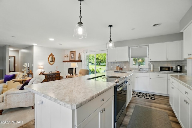 2101 Kimberly Dr, Lima, OH 45805 - kitchen featuring stainless steel range with electric cooktop, open floor plan, black microwave, light countertops, and recessed lighting
