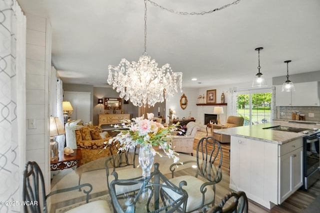 2101 Kimberly Dr, Lima, OH 45805 - dining area with wood finished floors, a chandelier, and a fireplace