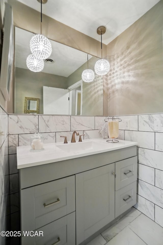 2101 Kimberly Dr, Lima, OH 45805 - bathroom featuring tile walls, a chandelier, vanity, and marble look tiles