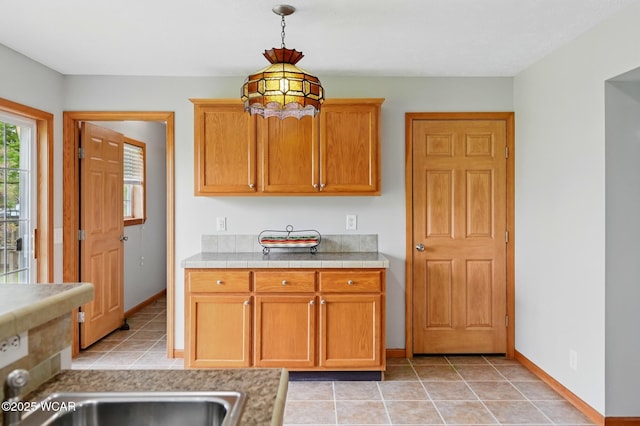 914 Howard St, Findlay, OH 45840 - kitchen featuring baseboards, pendant lighting, a sink, light tile patterned floors, and tile counters