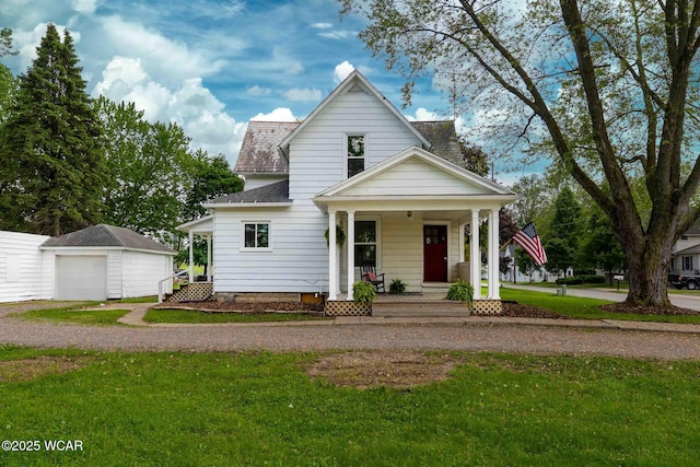 view of front of house with covered porch, a detached garage, a front yard, an outdoor structure, and a shingled roof