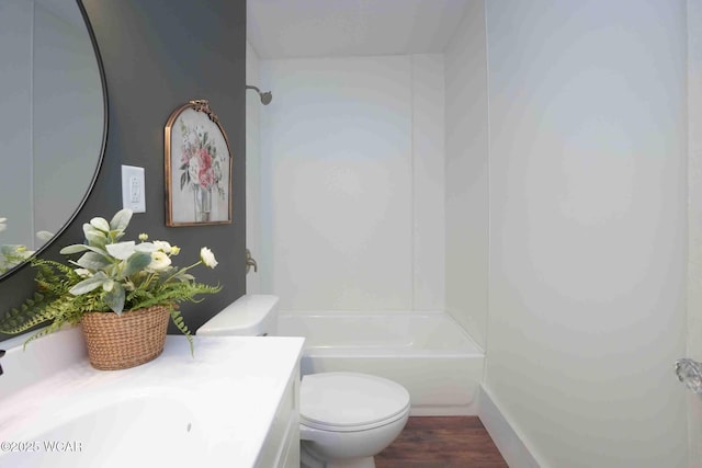 bathroom featuring toilet, vanity,  shower combination, and wood finished floors