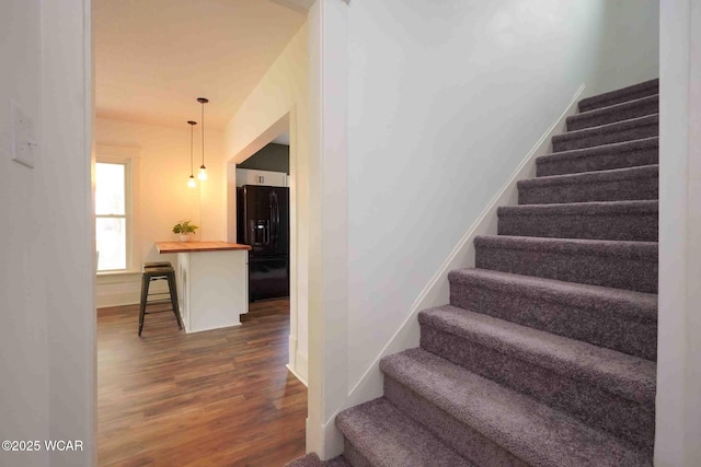 staircase featuring wood finished floors and baseboards